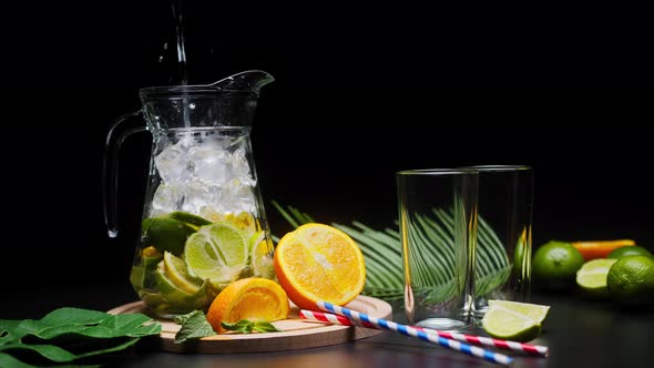Making Citrus Fruit Drink in Jug Pouring Carbonated Water Shooting of Cocktail of Orange Lemon and