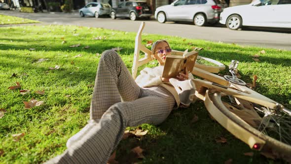 Stylish Woman with Wooden Eco Bicycle Reading a Book in the City Part