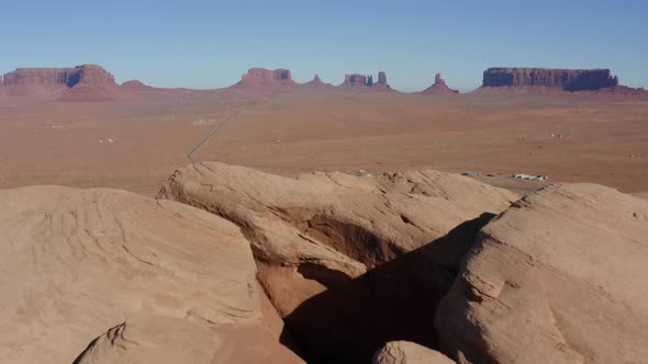 Aerial shot revealing a small Navajo village below Monument Valley Arizona