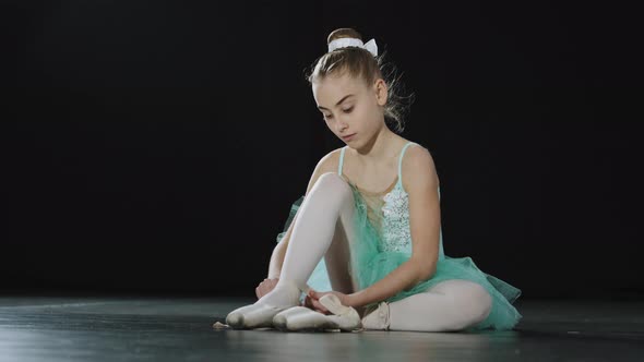 Teen Caucasian Girl in Tutu Sits on Floor Ties Ribbons of Pointe Shoes Young Ballerina Preparing for