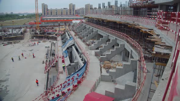 Arena Tribunes with Fences and Workers at Construction Site