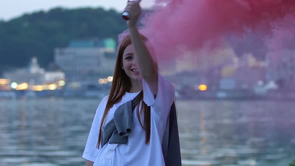 Happy Young Woman Holding Pink Color Bomb Enjoying Rest Outdoors, Festival