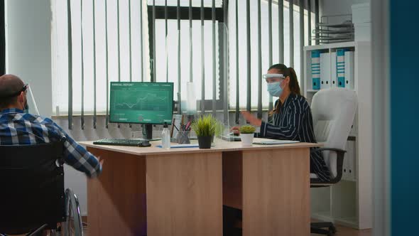 Manager Comming with Wheelchair at Workplace Wearing Mask