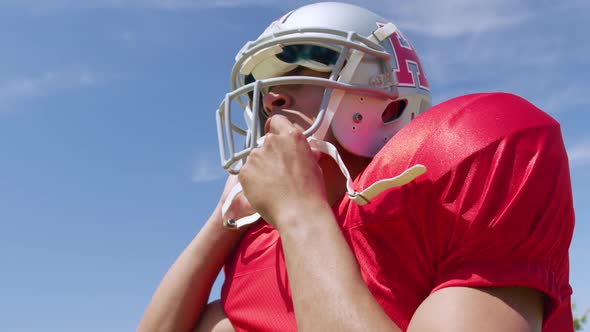 American football player standing with helmet