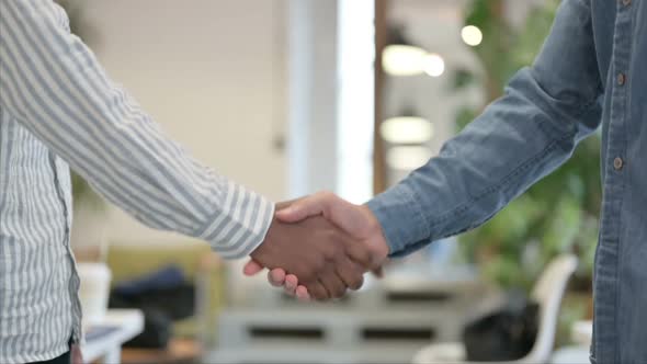 Close Up of African Man Shaking Hands with White Man