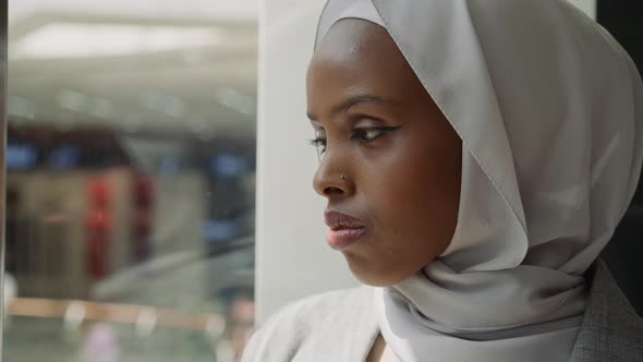 AfricanAmerican Woman Adjusts Hijab in Shopping Mall