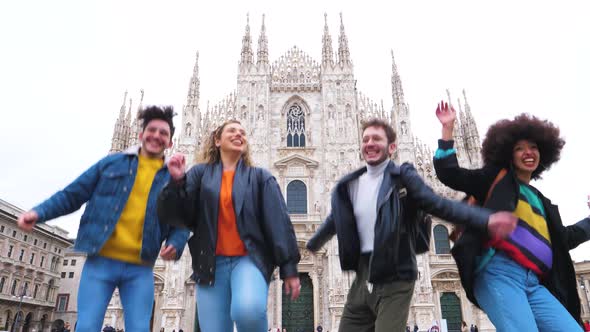 Group of for multiethnic people friends jumping in front of milan cathedral