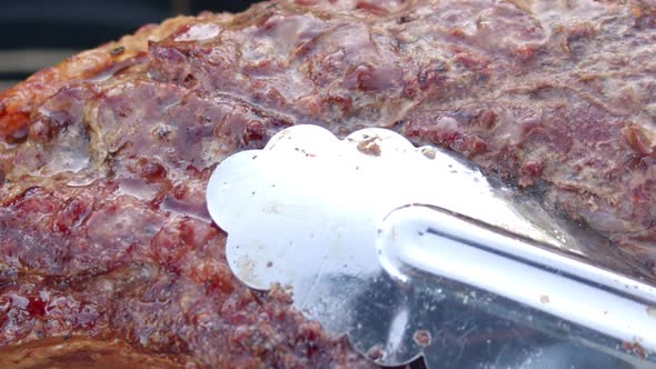 Delicious bubbling meat lifted with a forceps
