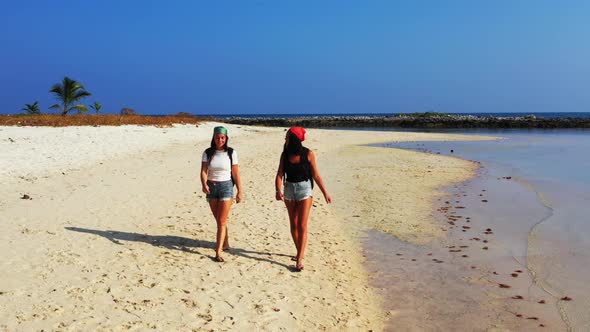 Women happy together on tranquil shore beach lifestyle by blue lagoon with white sand background of 