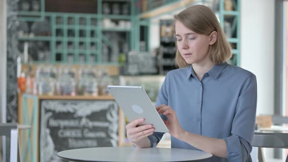 Attractive Young Woman Using Tablet in Cafe