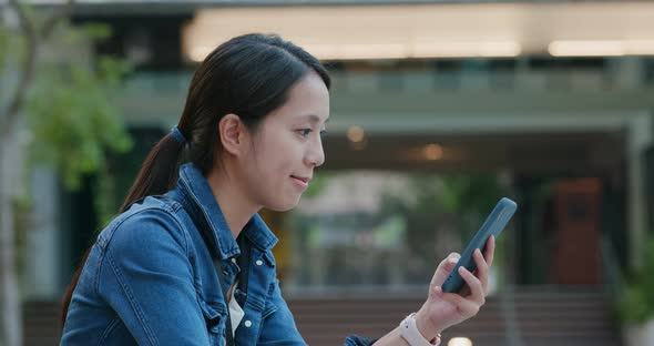 Woman hold with mobile phone in city