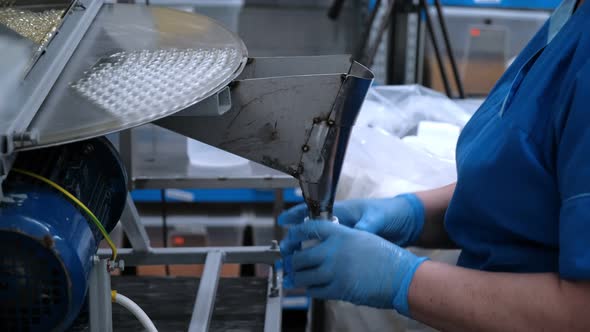 A Worker Packs Bottles at the Factory