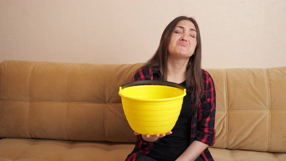 Sad Woman Collects Water Flowing Down From Ceiling on Sofa