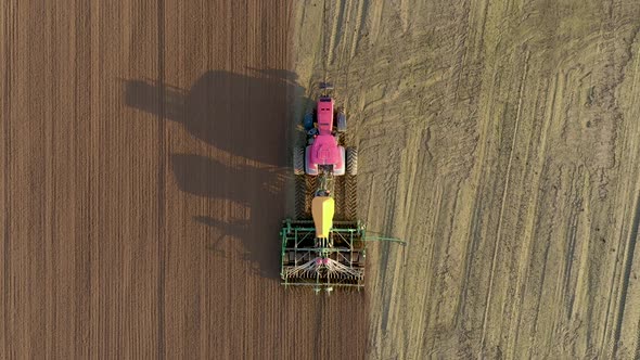 Tractor With Seeder Sows Corn Grains In Fertilized Soil Of Rural Field Aerial