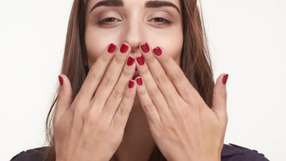 Attractive Young Caucasian Female with Long Brown Hair Sending Air Kiss and Smiling at Camera on