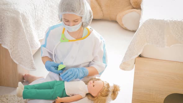 Beautiful Little Girl Playing Doctors with Doll at Home