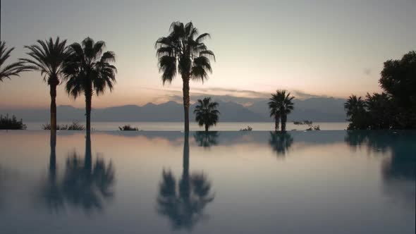  - Timelapse of Evening on Resort. Pool, Palms and Scene with Sea and Mountains