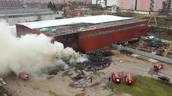 Aerial View of Firefighters Extinguishing Fire in Industrial Area