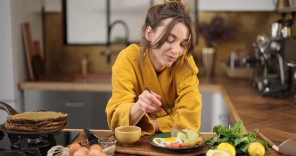 Woman Enjoyes Breakfast on the Kitchen in the Morning