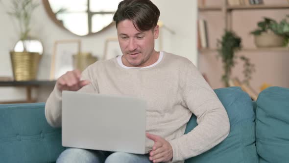 Middle Aged Man Coming Back Working on Laptop, at Home