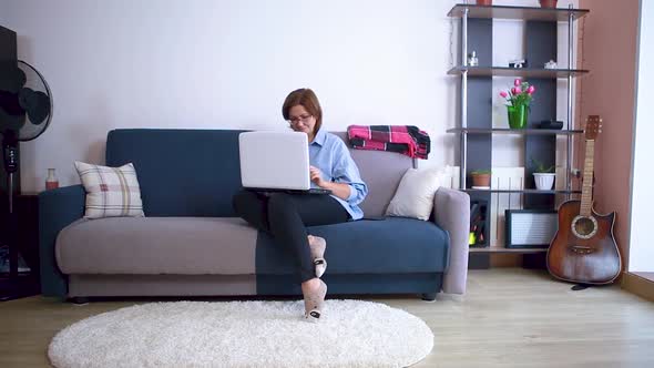 The Lady Is Typing on the Laptop While Sitting in the Room