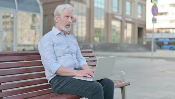Thinking Old Man Using Laptop While Sitting Outdoor on Bench