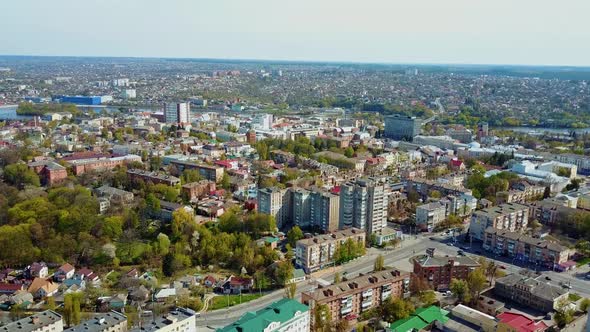 Panoramic view of a beautiful city. View from above on the urban buildings and green trees in summer