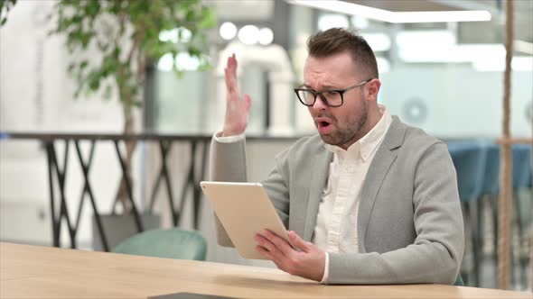 Disappointed Creative Man Reacting To Loss on Tablet