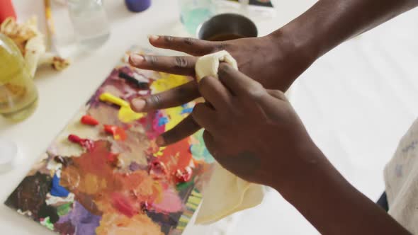 Mid section of african american male artist cleaning his hands at art studio