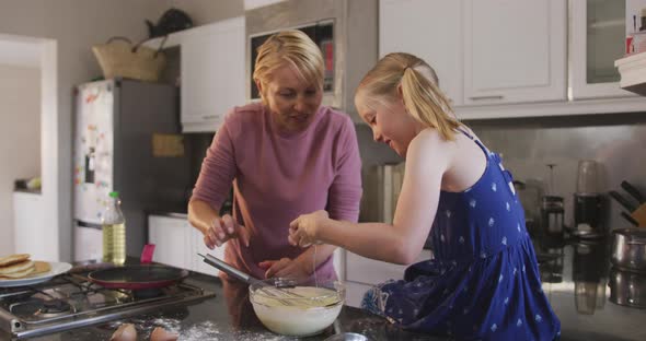 Side view of Caucasian woman cooking with her daughter at home