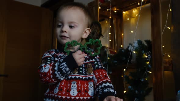 Happy Little Boy in Christmas Sweater with Funny Eyeglasses