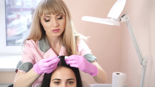 Handsome woman receives an injection in the head. The concept of mesotherapy.