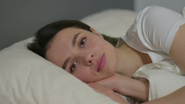 Young Woman Looking at Camera in Bed