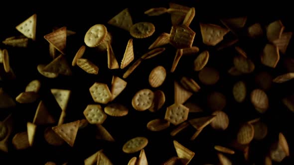 Salty Crackers Cookies Flies After Being Exploded. Pile of Golden Snacks Bouncing Against Camera