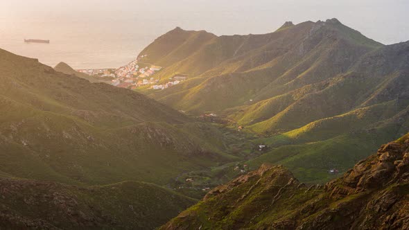 Tenerife Anaga Valley Sunrise with a village and a cargo ship in the ocean