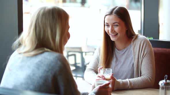 Two beautiful girls in a cafe