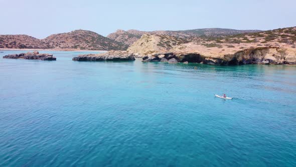 A kayaker paddles in the beautiful turquoise Libyan sea. Tripiti Beach the Greek island of Gavdos so