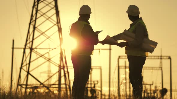 Silhouette of Engineers Looks at the Construction of Highvoltage Power