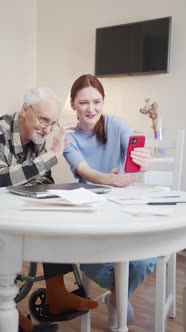 Grandfather and His Adult Granddaughter Communicate with the Family Via Video Communication on the