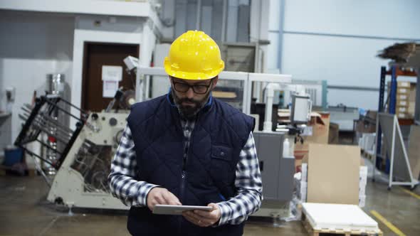 Confident Mature Factory Worker Using Tablet