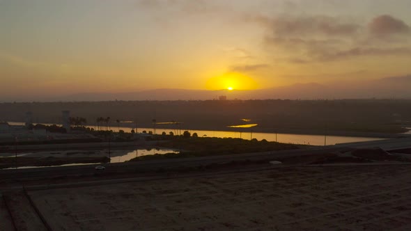 A drone captures a stunning sunset hyper lapse  as it rises up from the ground at the beach.