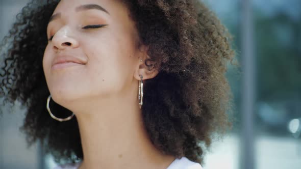 Happy Ethnic American African Woman Closes Eyes Enjoying Life Celebrating Dancing Street in Happy