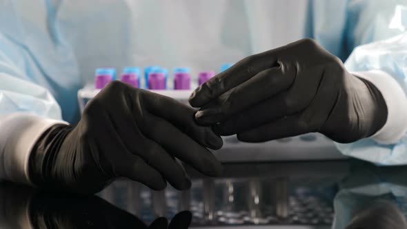 Lab Assistant in Black Gloves Working with Test Tube