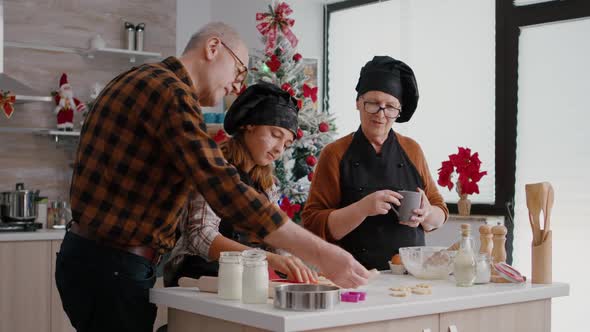 Grandparents Teaching Granddaughter How to Make Xmas Homemade Gingerbread