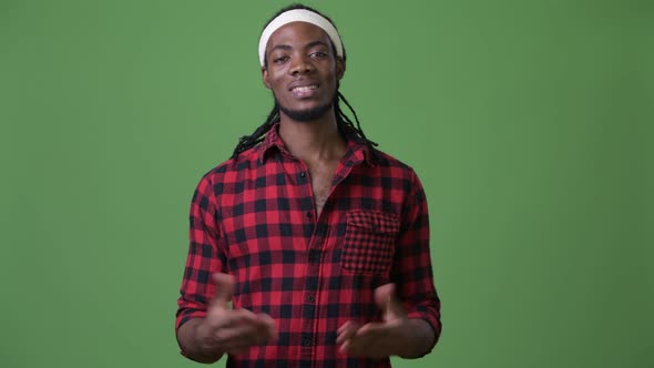 Young Handsome African Man with Dreadlocks Against Green Background