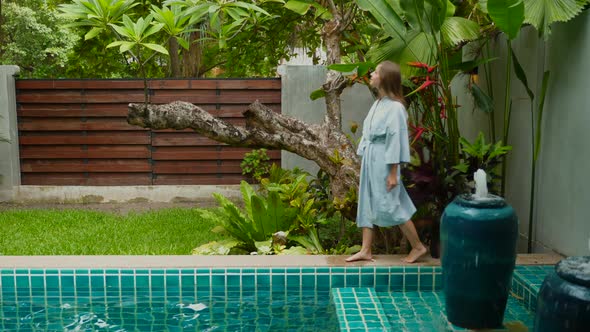 Happy Young Woman Walks Along Pool at Villa in Luxury Hotel Holidays Vacations