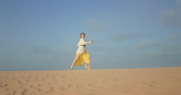 Slow Motion of Beautiful Woman in Flattering Dress Running By Rippling Sand Dune