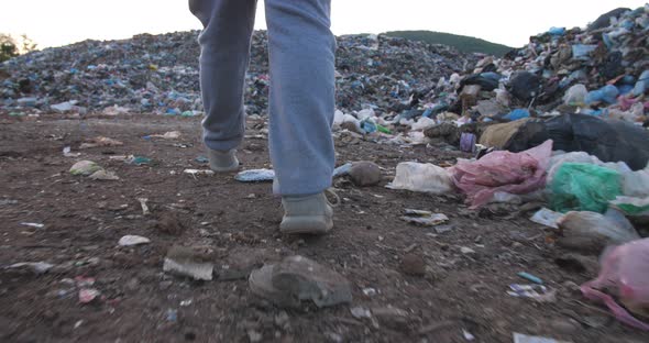 Boy Walking Near Garbage Pile