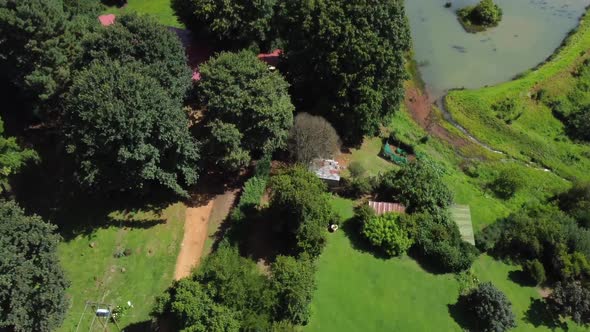 Drone shot of a horse farm in South Africa - drone is flying over the farm, revealing the mountains.