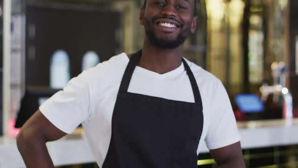 Portrait of african american barista smiling to camera wearing apron in cafe